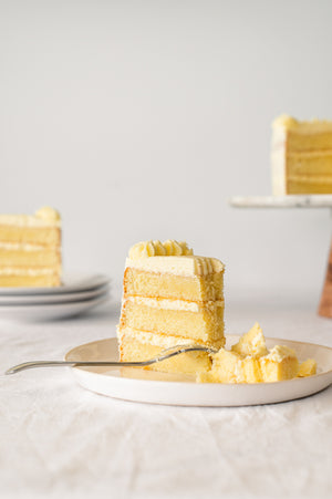 A slice of a three layer vanilla cake with vanilla buttercream 