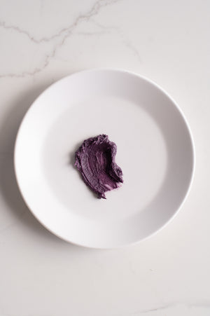 An organic shape of purple buttercream icing on a plate