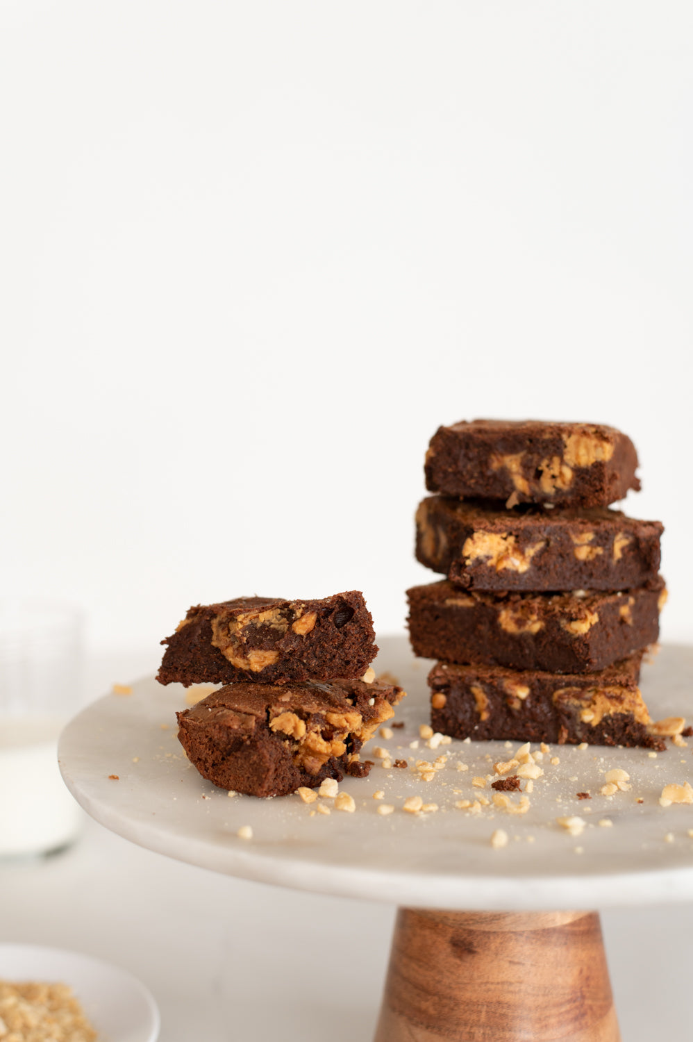 A stack of peanut butter and chocolate brownies on a cake stand
