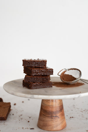 A stack of chocolate brownies on a cake stand 