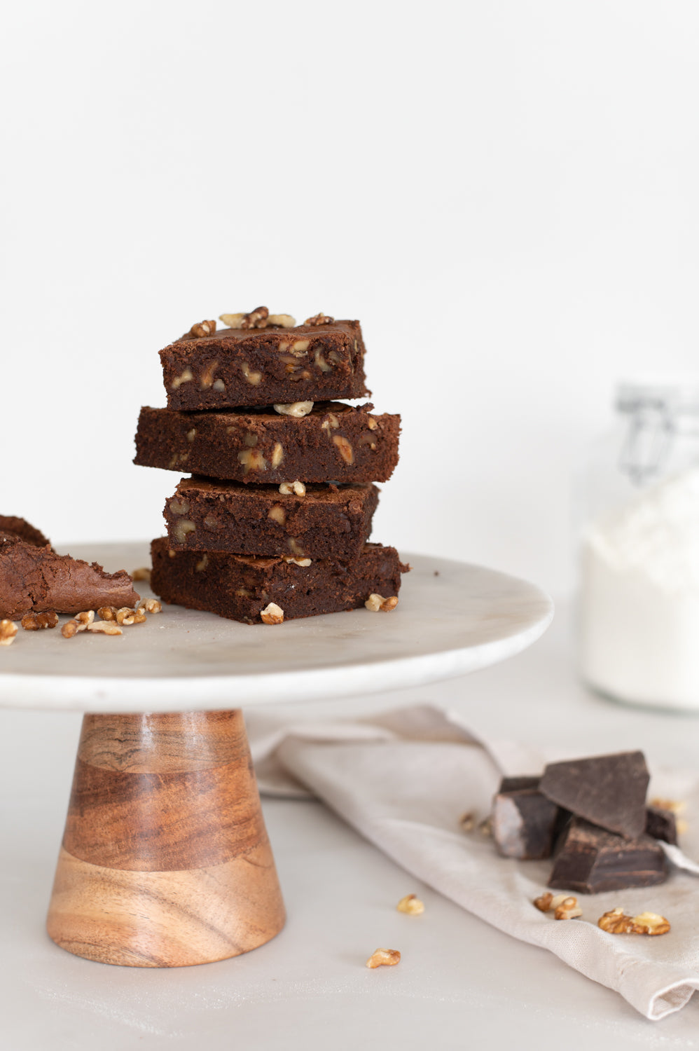 A stack of chocolate and walnut brownies displayed on a cake stand