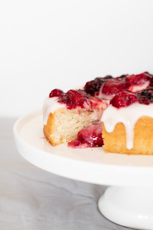 The inside of a lemon cake topped with coconut yoghurt icing and berry coulis 