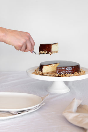A slice of nutella glazed Baked Cheesecake garnish with hazelnuts