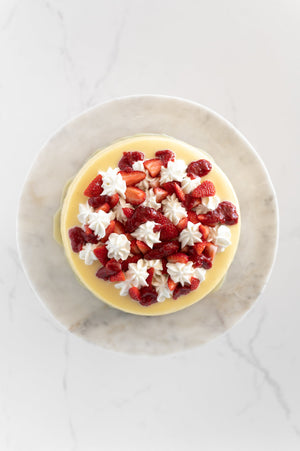 A top view of a strawberries and Cream Baked Cheesecake on a cake stand