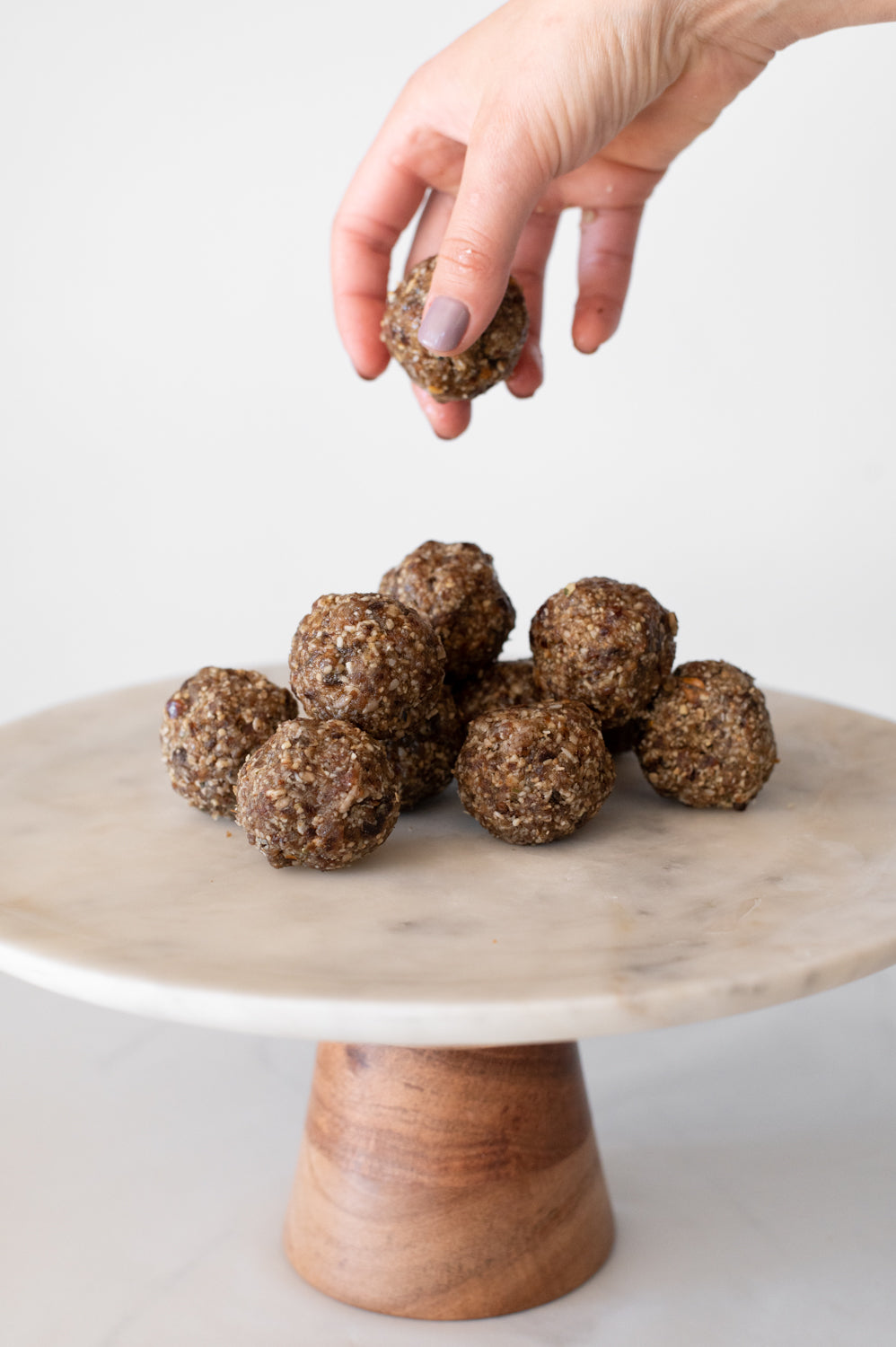 A pile of date balls on a cake stand