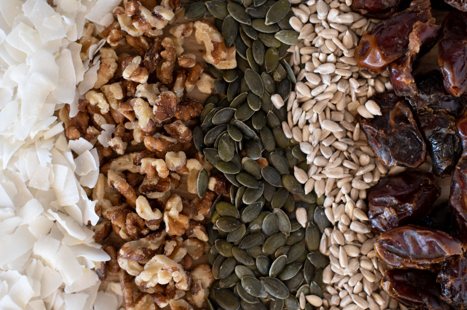 A selection of ingredients, including coconut, walnuts, sunflower seeds, pumpkin seeds and dates
