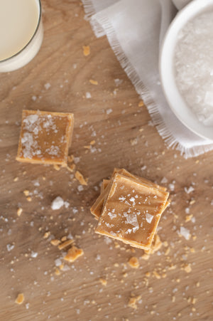 A top view of two pieces of salted fudge on a wooden board 