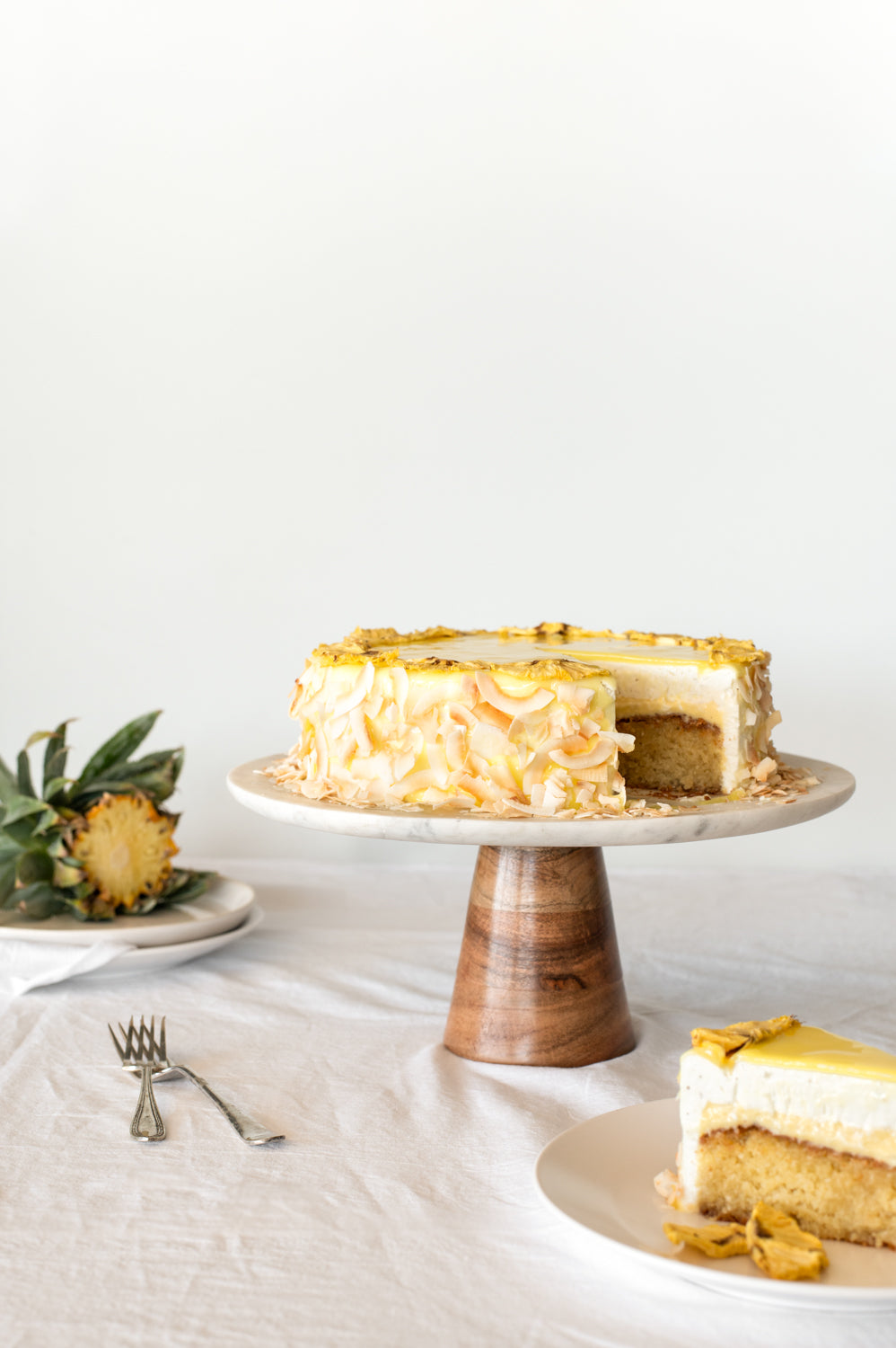 A yellow tropical cake garnished with pineapple and coconut