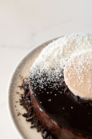 a close up of a triple Chocolate Mousse cake with white chocolate shavings on top